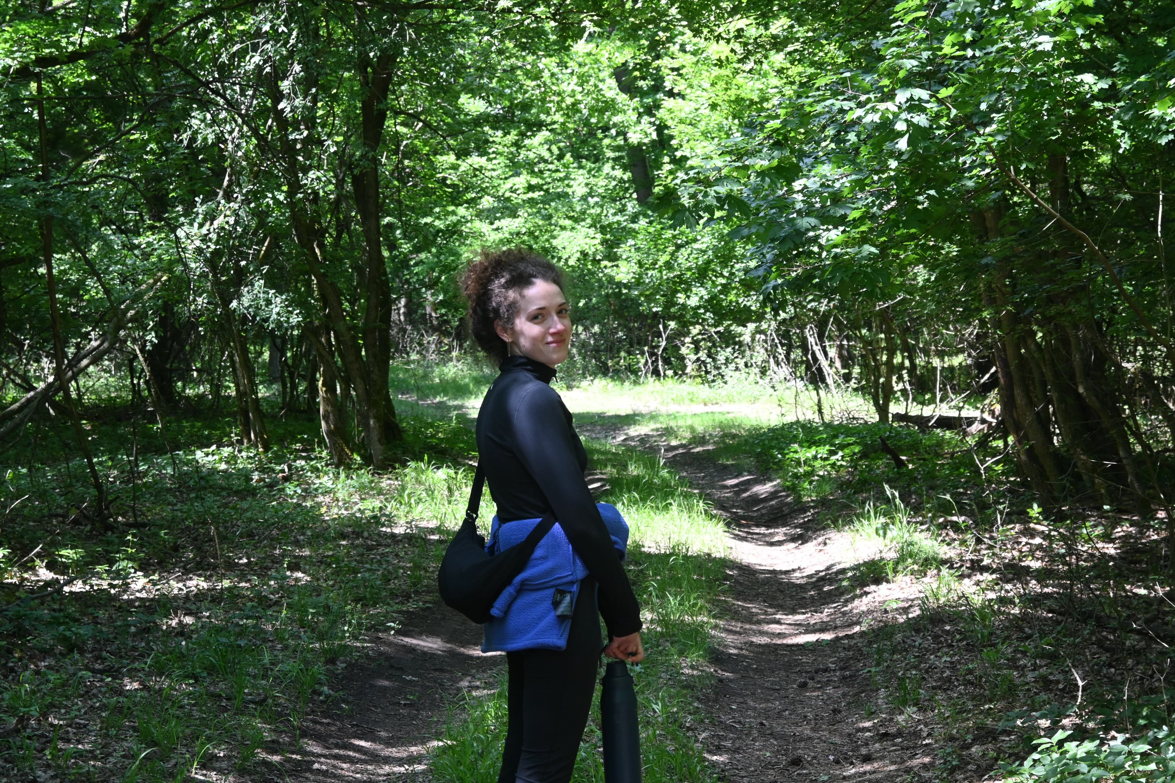 Dóra on a forest path, looking back over her shoulder